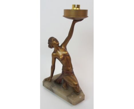 An Art Deco lady lamp modelled standing with arched back holding aloft the light fitting, upon circular onyx base, 38cm high 