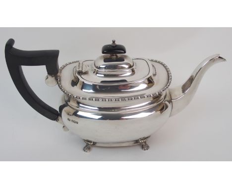 A three piece silver tea service by Emile Viner, Sheffield 1931, of rounded rectangular form with beaded border on four claw 