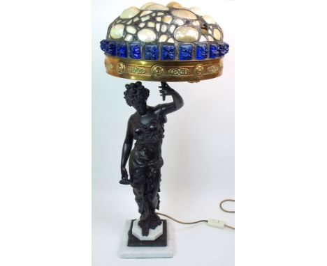 A spelter figural lamp modelled as a maiden holding aloft a torch, with a mother of pearl and coloured glass shade, upon marb