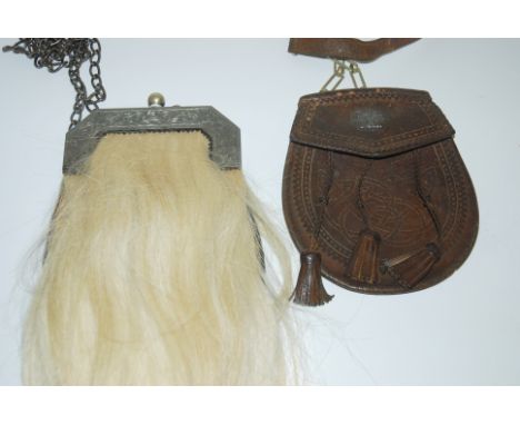 A leather and horse hair sporran with white metal clasp and Celtic knot decoration with a tooled leather sporran with a thist