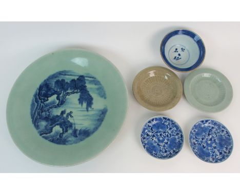 A Chinese celadon ground blue painted dish decorated with two figures fishing from a rock, blue four character mark, 38cm dia