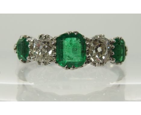 A five stone emerald and diamond ring scrolled crown mount in bright white metal, central step cut emerald approx 5mm x 4.5mm