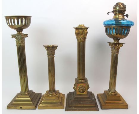 Four assorted brass Corinthian column oil lamp bases one with a pale blue glass reservoir, tallest 58cm high (4)