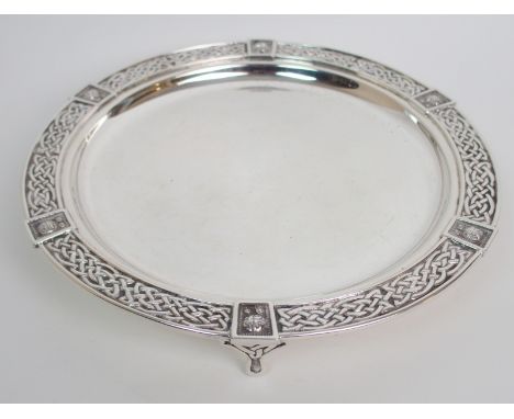 A silver card tray by Brook & Son, Edinburgh 1932, of circular form, the rim with Celtic decoration on three feet with Celtic