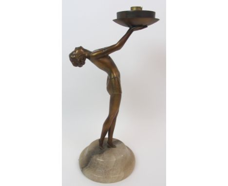 An Art Deco spelter lady lamp modelled crouching, holding aloft the light fitting, upon triangular shaped onyx base, 31cm hig