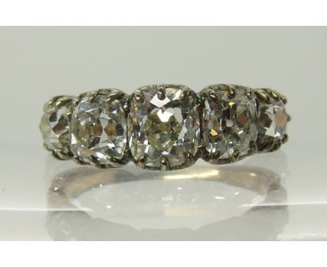 A five stone old cushion cut diamond ring in yellow and white metal cut back clawed mount, diamonds estimated approx 3.28cts 