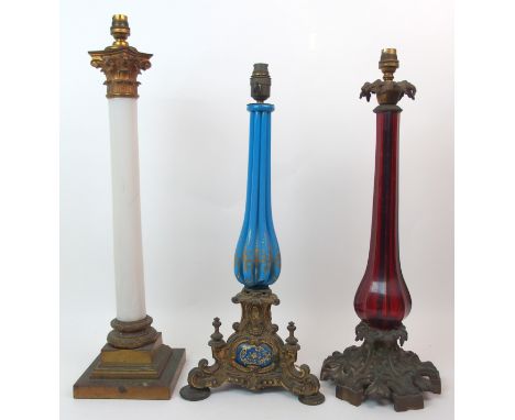 A Victorian ruby glass table lamp with cast metal acanthus leaf base and fitting, together with a blue glass example with scr