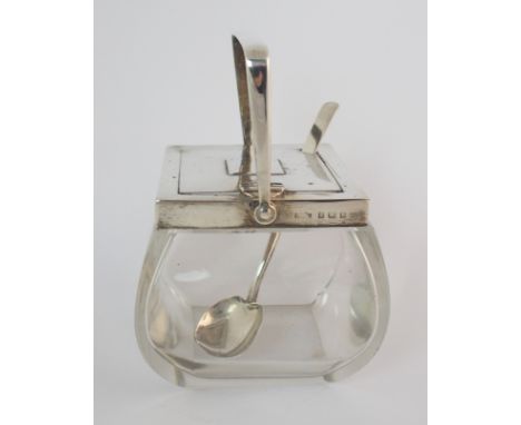 An Edwardian silver topped glass sugar bowl by Asprey & Company, Birmingham 1909, the rounded square body with a swing handle