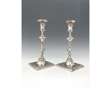 A pair of George III silver cast candlesticks, each with stepped square base and knopped stem, decorated with egg and dart bo