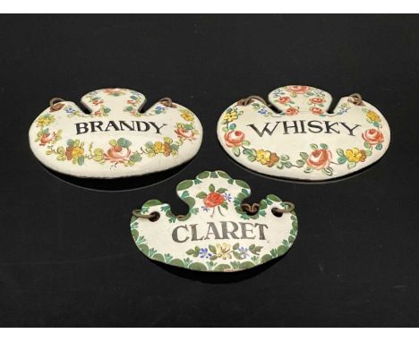 A group of three nineteenth-century Continental enamelled escutcheon form wine labels or bottle tickets, decorated in polychr