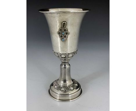 An Israeli silver and gem set kiddush cup, pedestal form with trumpet bowl and splayed foot, applied with ropetwist grape mot