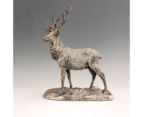 An Elizabeth II hallmarked silver model of a stag, the body decorated to simulate hair, atop a base formed as a rocky outcrop