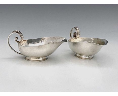 R. E. StoneA pair of George VI silver sauce boats, the planished body with scroll handle formed as a foliate tendril with sty