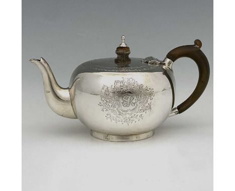 A Victorian silver teapot, of bullet shape form and modelled in the early George II style, with turned wooden handle and fini