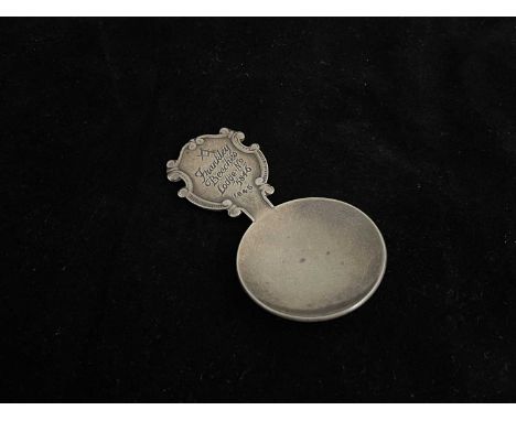 Masonic Interest.A twentieth-century silver tea caddy spoon, the plain bowl with thumbpiece surmounted by scrolls and engrave