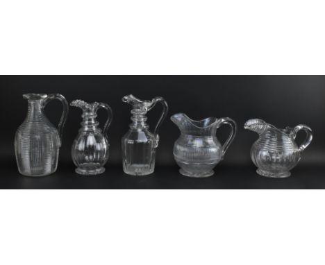 Five early 19th century c1820 George IV step cut jugs, three being water pouring jugs and two claret jugs. The lot comprising