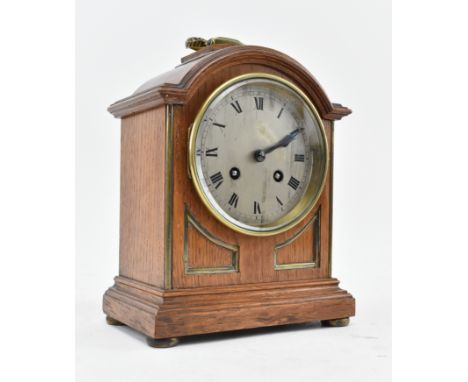 A vintage 20th century French oak and silvered dial mantle clock. The clock featuring brass ring handle to top, with central 