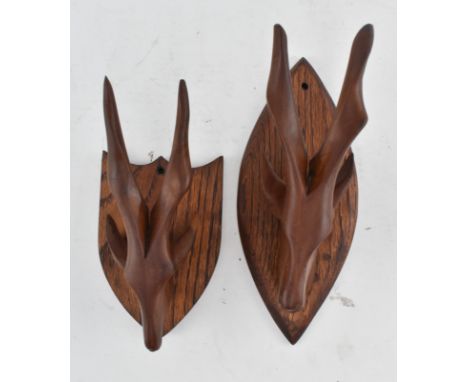 A pair of vintage 20th century carved wood tribal antelope head wall hanging plaques / hangers. Each plaque having shaped ant