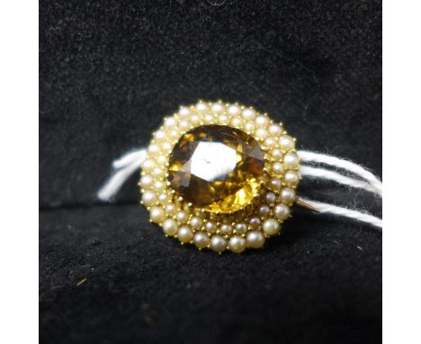 A late Georgian yellow gold, topaz and pearl cluster brooch composed of a large central faceted yellow topaz framed by 2 oute