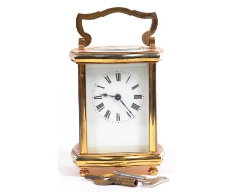 A BRASS CARRIAGE TIMEPIECE WITH ENAMEL MASK DIAL IN SERPENTINE CASE, 11CM H EXCLUDING HANDLE, EARLY 20TH C 