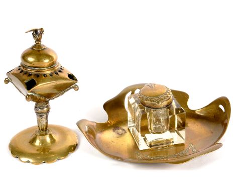 A JUGENDSTIL PIERCED BRASS AND GLASS MOUNTED INKWELL AND AN EASTERN BRASS OIL LAMP WITH DOMED LID AND BIRD FINIAL, 13CM H 