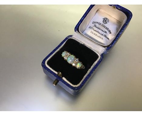 An opal and diamond ring, the three graduated oval-cut opals spaced by two pairs of round brilliant-cut diamonds, all claw-se