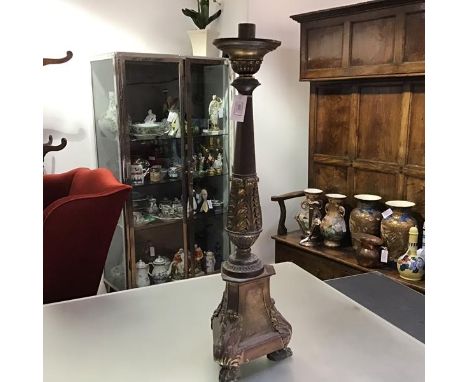 A 19th century parcel-gilt copper floorstanding altar candlestick, in Baroque style, with tapering leaf-cast baluster standar