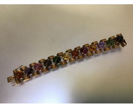 A 9ct gold bracelet set with specimen semi-precious stone cabochons, the twelve stones including obsidian, amethyst, carnelia