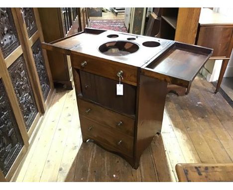 A George III mahogany washstand, the rectangular fold-out top opening to a fitted interior with lift-up mirror, above a tambo