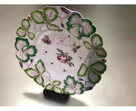 A Longton Hall porcelain "Strawberry Leaf" plate, c. 1755-60, enamel painted to the well with floral sprays and a butterfly i