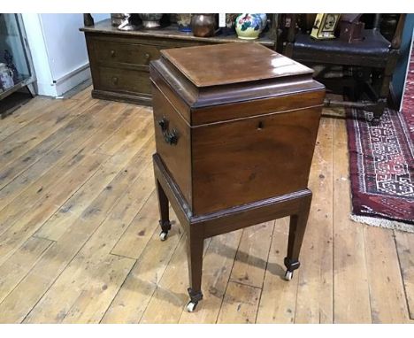 An early 19th century satinwood crossbanded mahogany cellarette, of square form, the hinged caddy top opening to nine bottle 