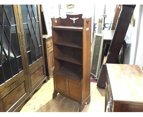 An Arts &amp; Crafts open bookcase, the top shelf with pierced gallery over three further shelves and a pair of panelled cupb