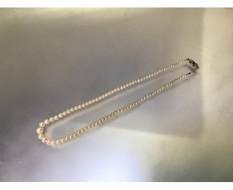 An emerald and diamond mounted single strand cultured pearl necklace, the graduated strand on an 18ct white gold clasp centre