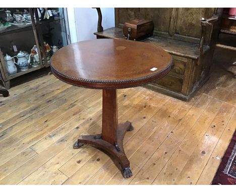 A Regency amboyna tripod table, the circular top with beaded rim on a concave tapering standard over a conforming triform pla