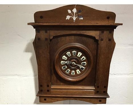 A Continental oak wall clock in the Secessionist taste, c. 1900, the oak dial with enamel Roman numerals within a case decora