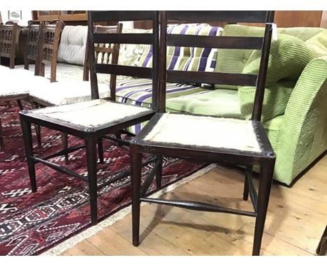 A pair of Arts &amp; Crafts ebonised chairs, c. 1900, each ladder back above a formerly caned seat, raised on tapering turned