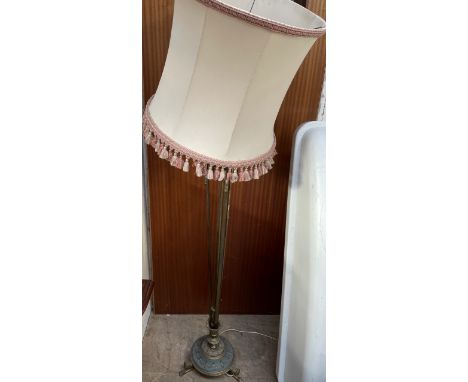 A standard lamp with rams head moulded decoration on a tapering column and circular base