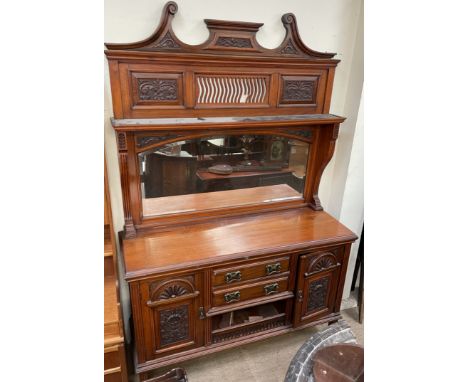 An Edwardian walnut mirrorback sideboard, with a carved cresting, shelf and arched mirror, the base with drawers and cupboard