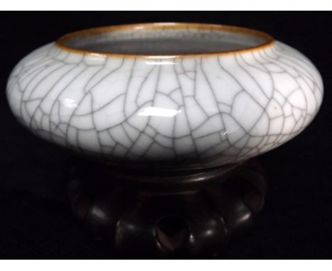 Chinese Ge Gu style shallow ceramic Dish on wooden stand. Typical crackle glaze pottery with iron oxide bleed through colour 