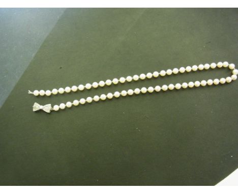 A cultured pearl single-row necklace to the partial platinum diamond bow-shape clasp - Set with brilliant and single-cut diam