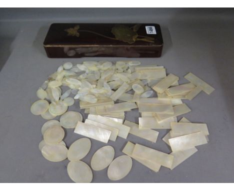 A good collection of Oriental mother of pearl gaming counters - various styles and sizes in a lacquered box - in excess of 50