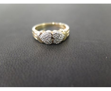 A 9ct gold diamond dress ring - Designed as two hearts - Partial hallmark - Ring size N - Weight approx 2.9gms
Condition Repo