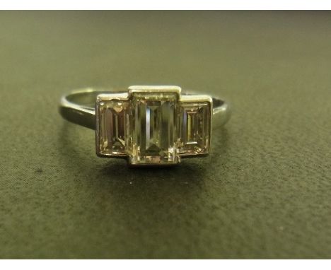 A diamond three-stone ring - The graduated emerald-cut diamonds to the plain band - Estimated total diamond weight 1.50cts - 