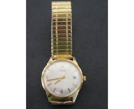A Garrard Automatic 9ct gold central sweep calendar dial wristwatch with a rolled gold strap engraved to back - working in sa