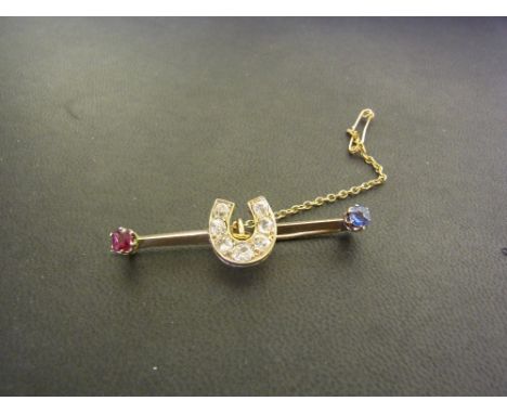 An early 20th century gold diamond, sapphire and ruby bar brooch - The old-cut diamond horseshoe to the ruby and sapphire ter