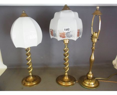 Two similar brass open twist table lamps and a single lamp