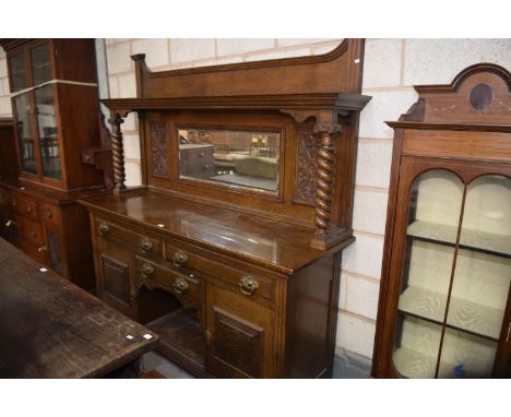 A Victorian carved oak mirror back sideboardWith substantial spirally lobed columns enclosing a mirrored plate, the base with