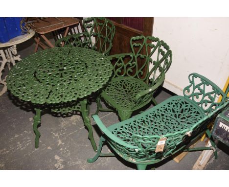 A Painted metal four piece patio set comprising a circular openwork table on cast naturalistic legs, a pair of elbow chairs a