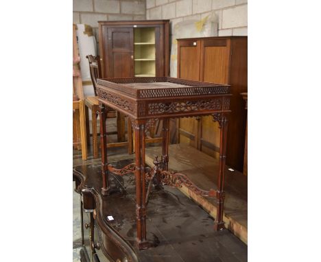 A Chinese Chippendale style mahogany silver table with a openwork gallery raised upon ring turned cluster column legs. 