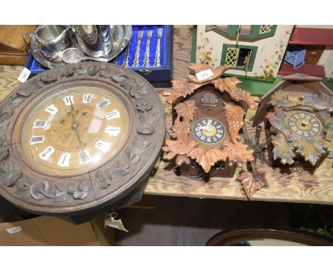 A carved black forest oak wall clock Carved with flowerhead and leaves, with two train movement striking on a coiled spring, 